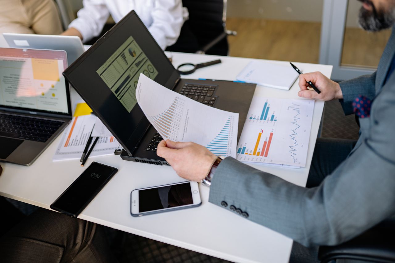 Profissionais analisando relatórios financeiros para elaborar um fluxo de caixa projetado confiável.