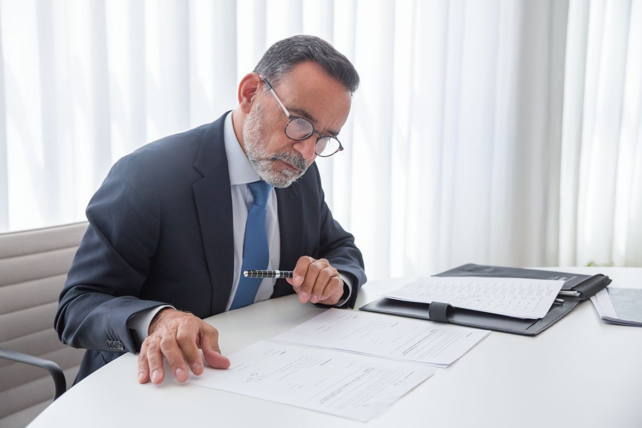 Gestor analisando documentos para apoiar decisões relacionadas à sustentabilidade empresarial e ao planejamento estratégico. 